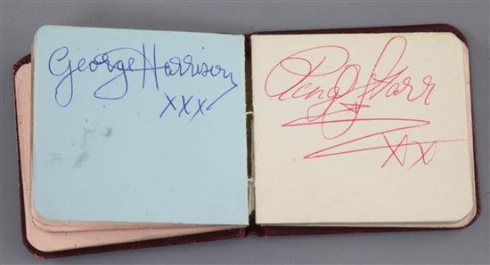 The Beatles: A small red leather bound autograph album with assorted autographs 2.5 x 2.75in.